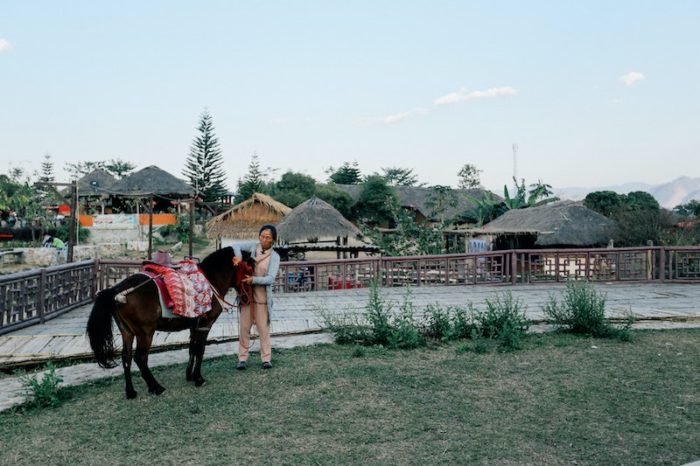 A woman pets her pony in Pai, a popular day trip from Chiang Mai.