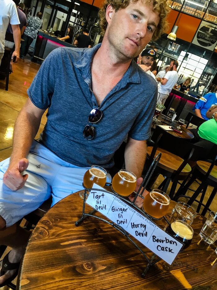 A man sits at AleSmith Brewing in San Diego with a taster in front of him.