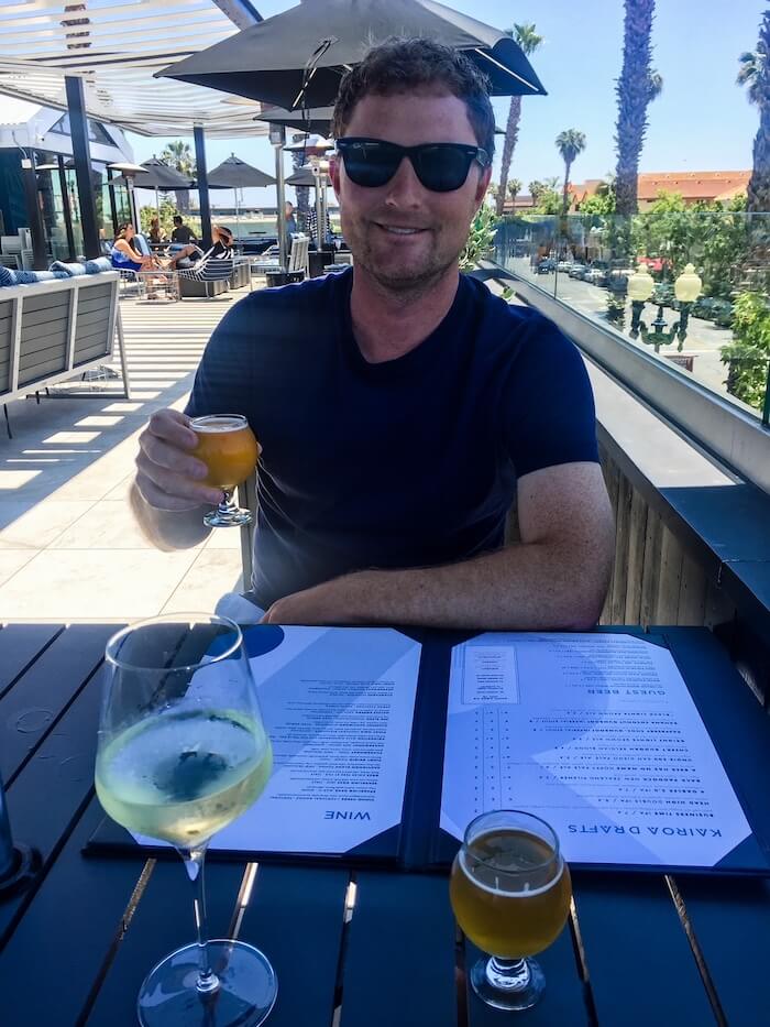 A man sits at Kairoa Brewing in San Diego with a beer in his hand.
