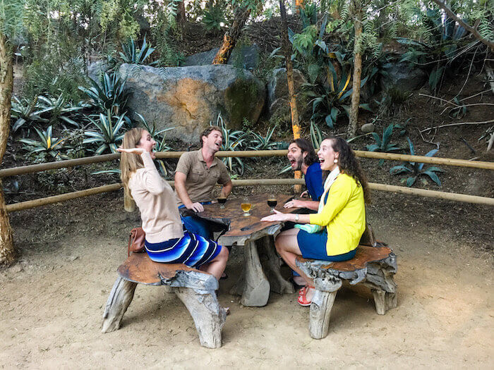 Two women and two men laugh at Stone brewery's beer garden in San Diego.