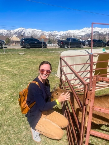 A woman pets a goat at a farm in Utah.