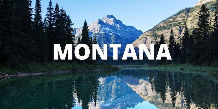 Mountains reflected in a lake with MONTANA in the foreground