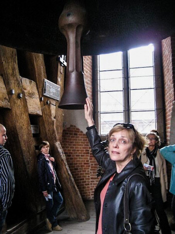 A woman rubs a bell in Poland.