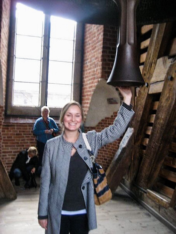 A woman rubs a bell in Poland.