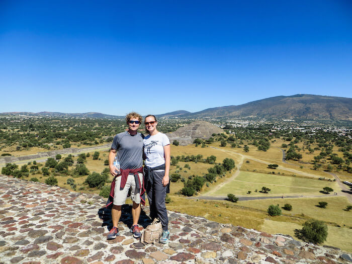 A couple stands at the top of ruins outside of Mexico City.