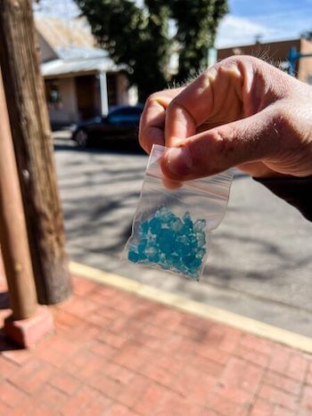 A man holds a bag of rock candy on a self-guided Breaking Bad tour.