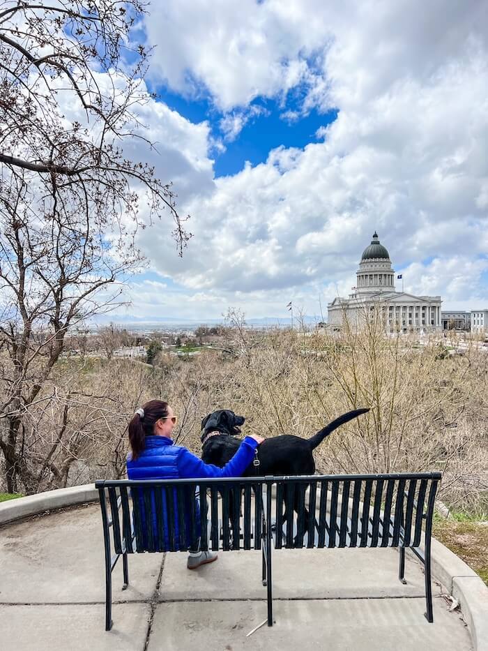 A woman and her pup looking at views of the Utah State Capitol in Salt Lake City