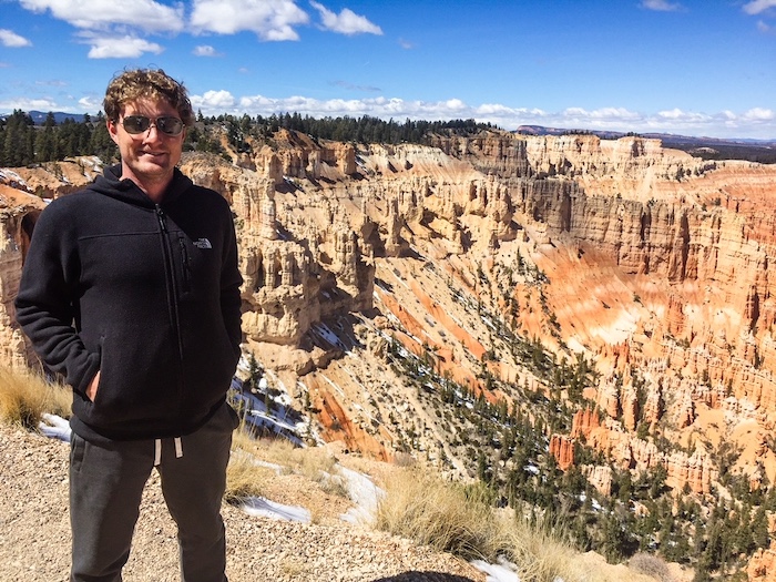 A man poses at Bryce Point at Bryce Canyon National Park.