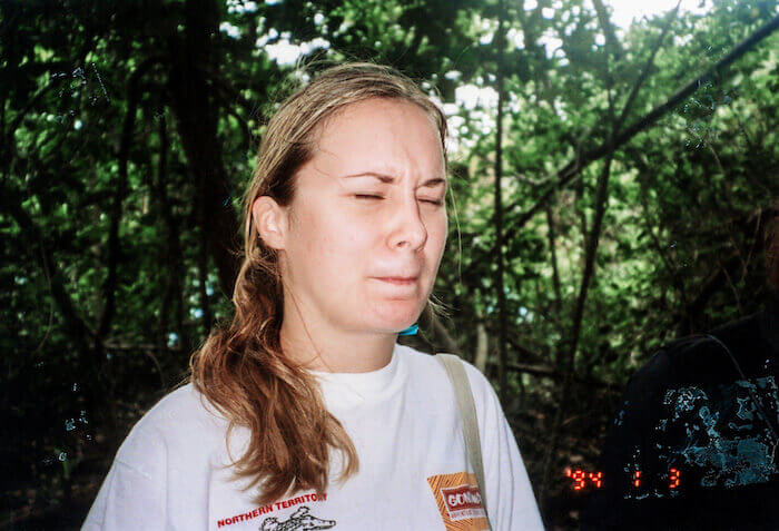 A woman eats ants in the jungle.