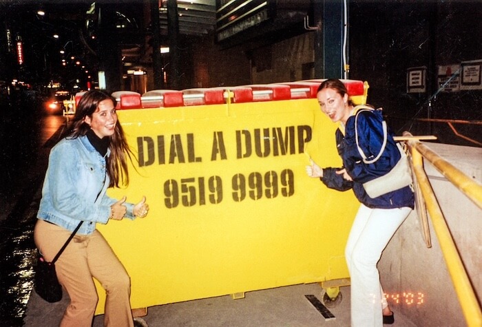 Two women have fun at a dump truck.