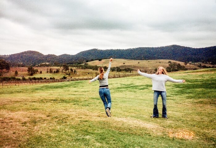 Two women dance in a field.