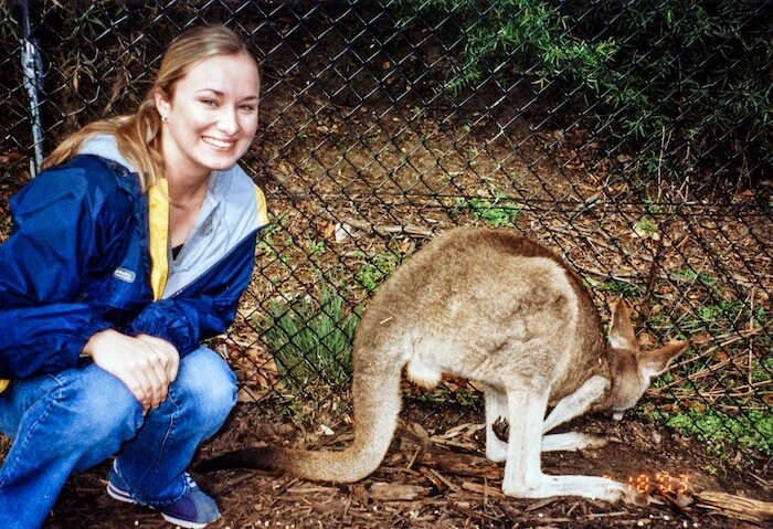 A woman poses with a kangaroo.
