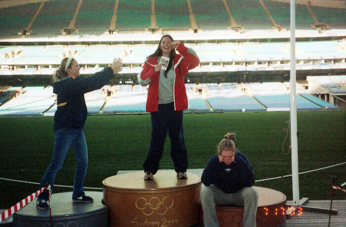 Friends pose on an Olympic podium.