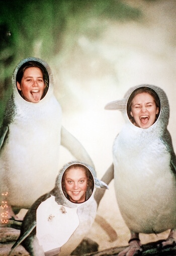 Three girls pose as penguins.