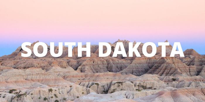 A pink sky against the Badlands with SOUTH DAKOTA across the front