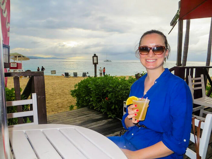 A woman sips on a cocktail on an island vacation.