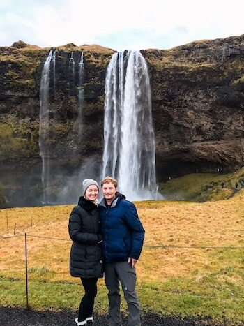 A couple poses at Seljalandsfoss in Iceland.