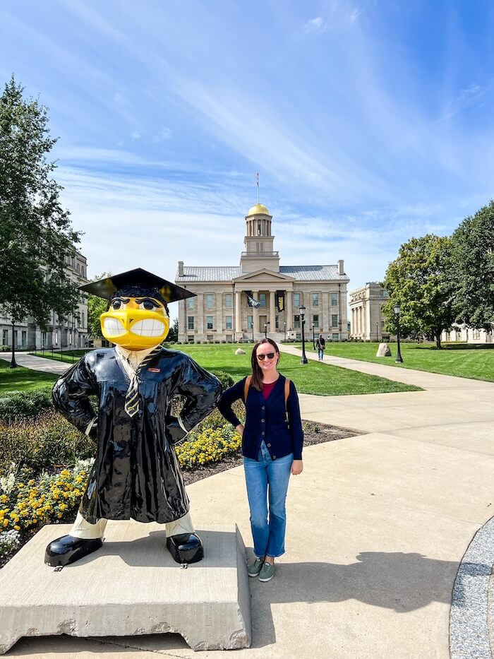 A woman poses with the University of Iowa mascot, one of the best things to do in Iowa City.
