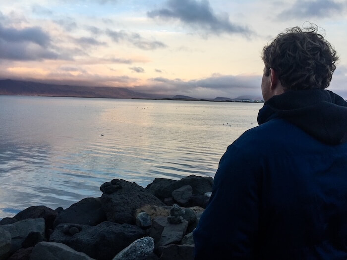 A man stands at a viewpoint in Iceland.