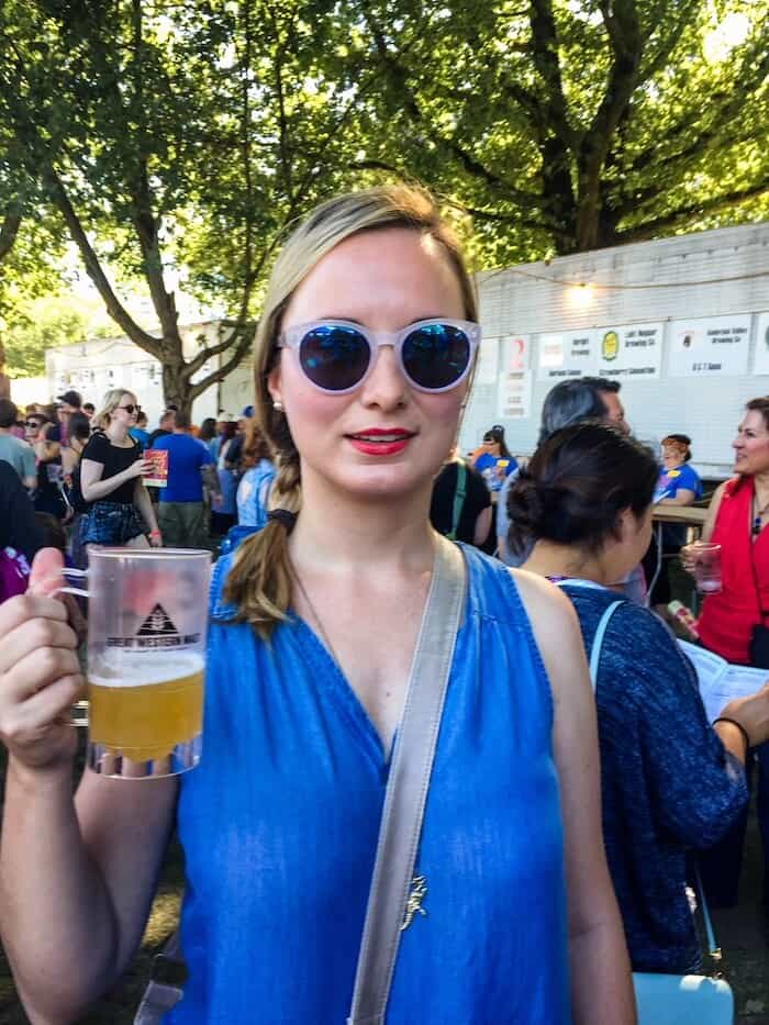 A woman sips on beer at a festival in Portland