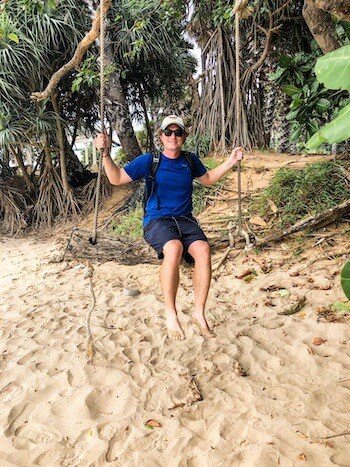 A man on a beach swing on a Thai beach