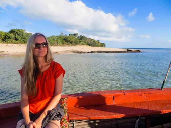 A woman sits pensively on a boat.