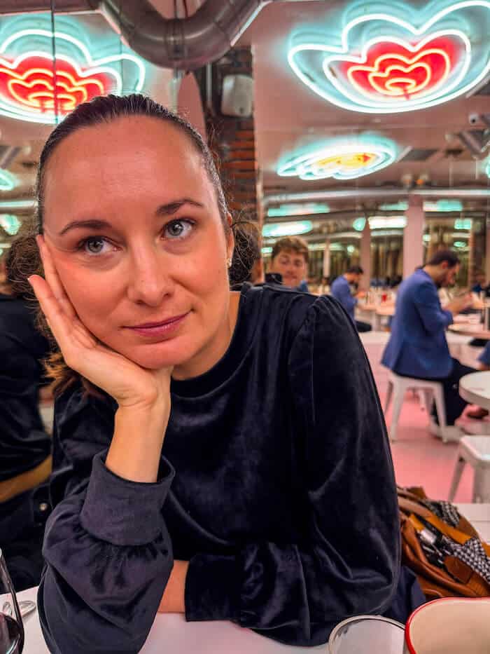 A woman thinks about something interesting at a pizza shop.