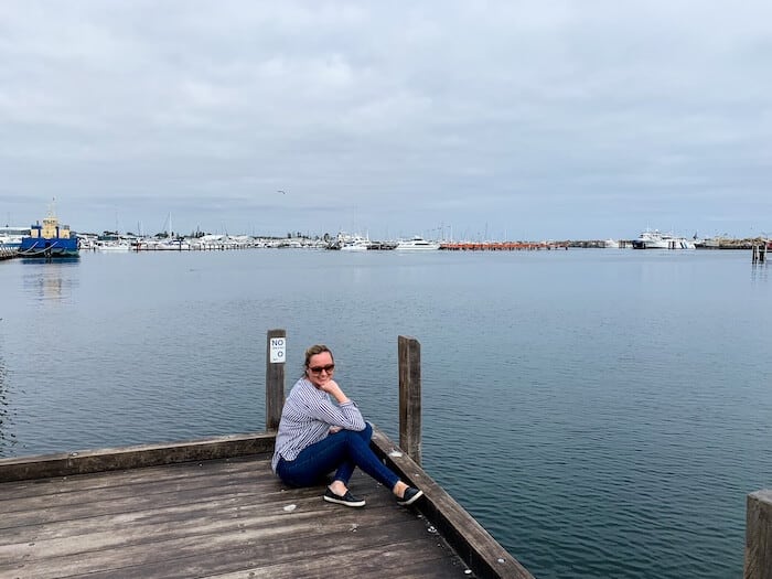 A woman poses on a dock in Australia.