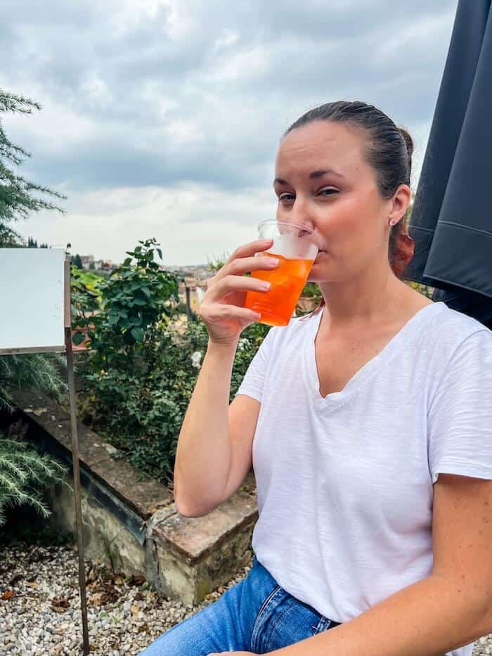 A woman sips on a cocktail in Italy.