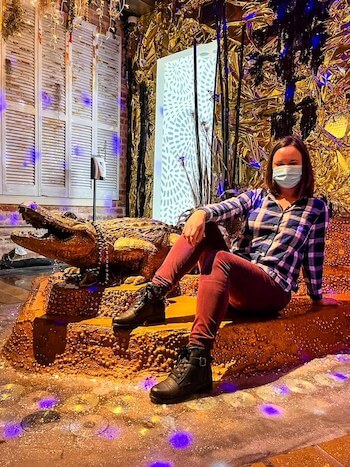 A woman poses with a gator at an art museum in New Orleans.