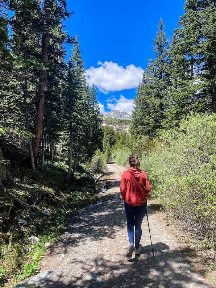 A woman walks away from the scene on a hike.
