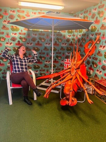A woman laughs with a lobster in New Orleans.