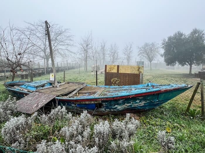 An abandoned boat in Torcello against a foggy sky
