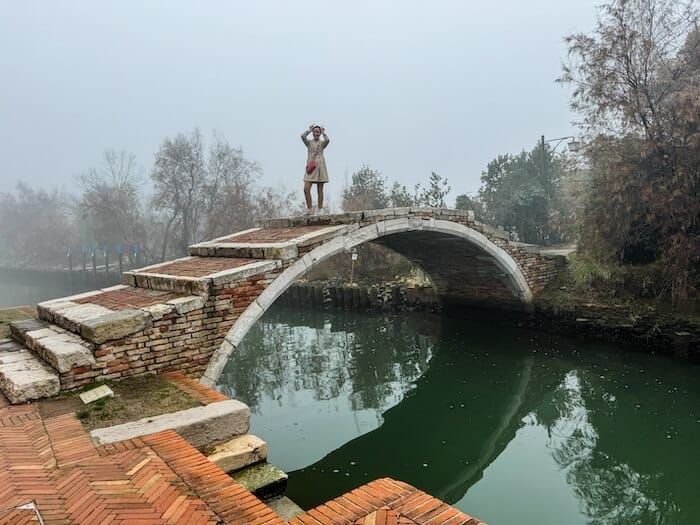 A woman poses on the Devil's Bridge in Torcello.