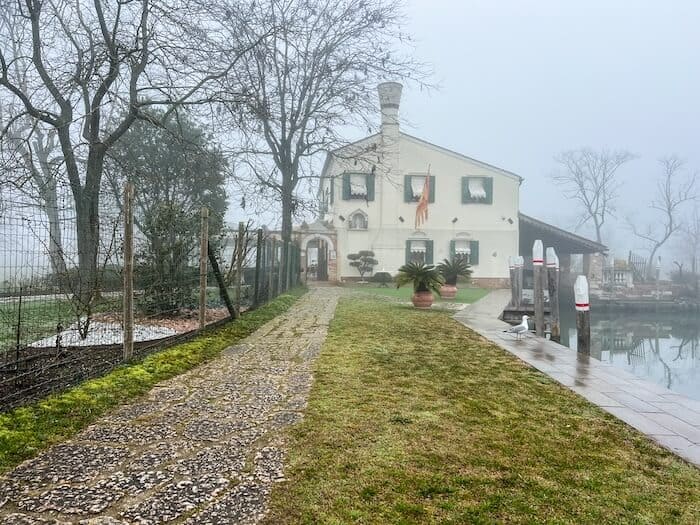 An eerie walkway in Torcello with a home in the background