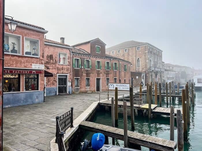 A foggy day in Murano with boats at the dock