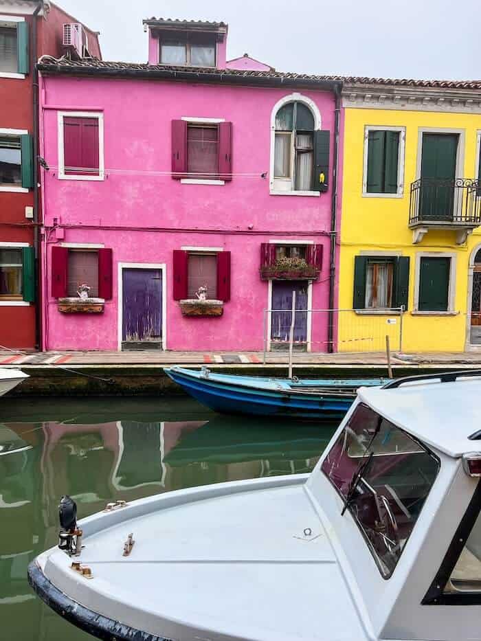 Colorful buildings in Burano with a boat whizzing by