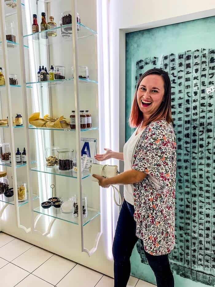 A woman poses with what look like medicine bottles at Realm of the 52 Remedies, an apothecary-themed speakeasy in San Diego, California.