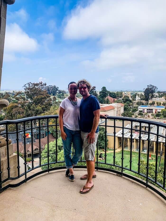 A couple poses at the top of the California Tower in San Diego, California.