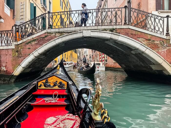 A view from inside a Venice gondola as it passes underneath a bridge