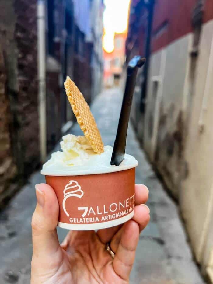 A woman holds a cup of gelato in Venice, Italy.