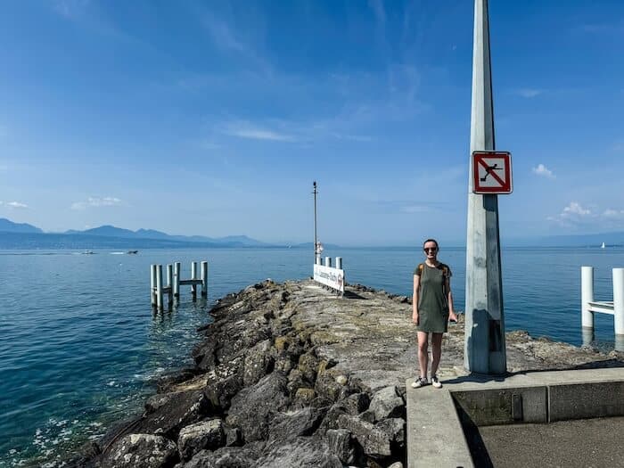 A woman stands at the harbor of Lausanne, Switzerland.