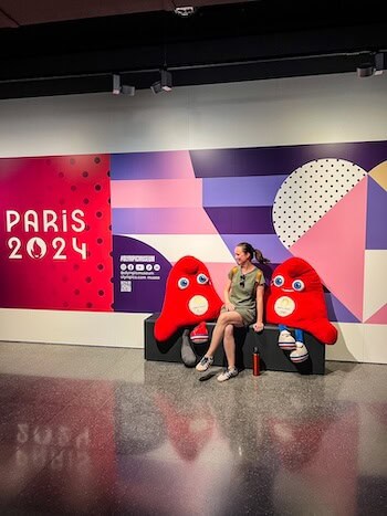A woman poses with two mascots at the Olympic Museum in Lausanne, Switzerland.