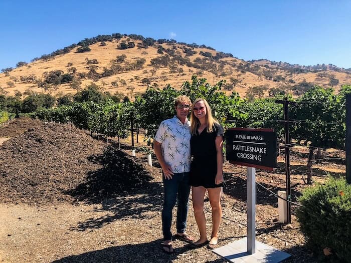 A couple poses at a vineyard in Napa.
