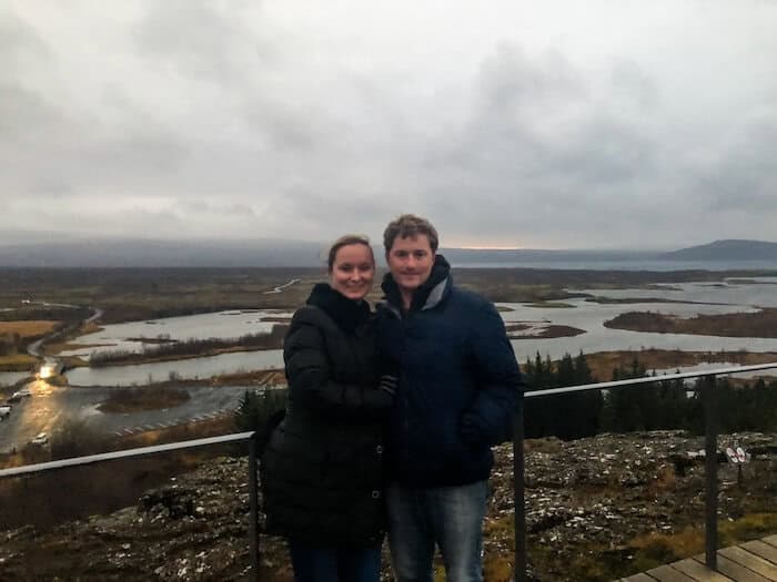 A man and woman pose at Thingvellir National Park in Iceland.