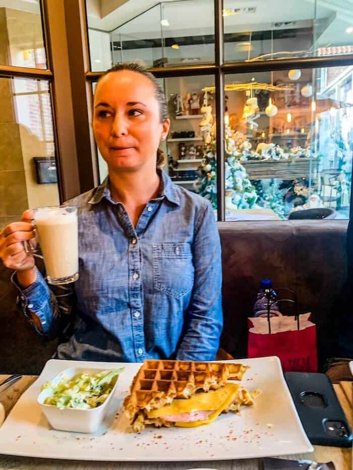 A woman eats waffles with coffee in Bruges.