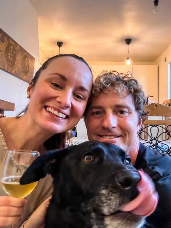 A couple poses with their dog.