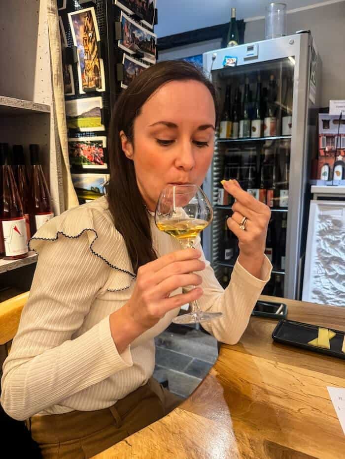 A woman sips on white wine in Alsace.