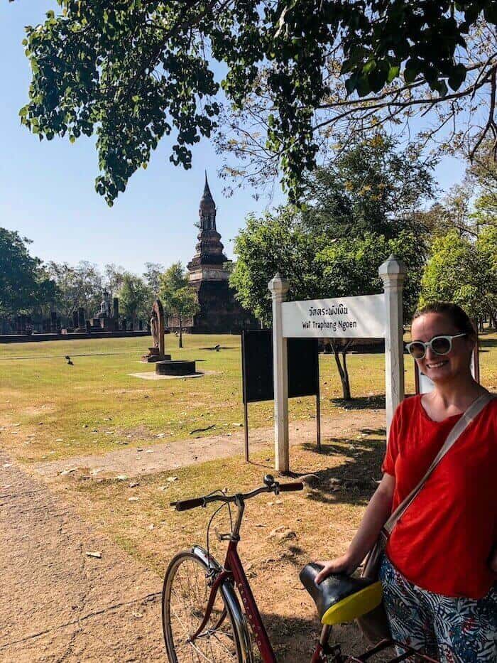 A woman poses with a bike in Thailand.