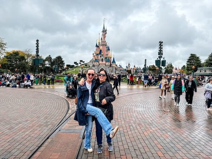 Two women pose at a Disney park in Paris.